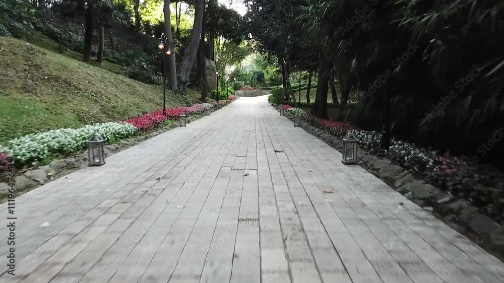 Drone shot of a winding wooden path in a beautiful garden Drone shot of a winding wooden path in a beautiful garden