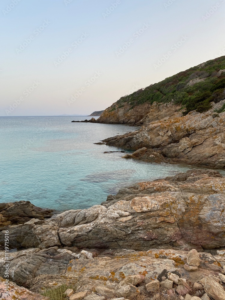 Rocky coastline with clear turquoise waters at dusk Rocky coastline with clear turquoise waters at dusk