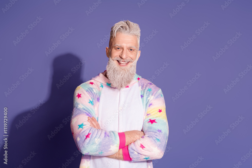 Joyful mature man in trendy unicorn pajamas poses against purple background Joyful mature man in trendy unicorn pajamas poses against purple background