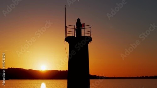 Silhouetted Lighthouse During Golden Sunset In Muxia, A Coruña, Spain. - aerial shot