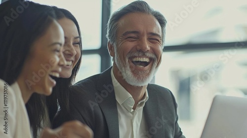 Laughter fills the air as three business professionals engage in lighthearted conversation within a modern office environment, highlighting teamwork and camaraderie