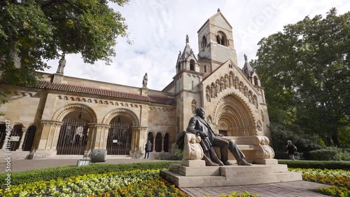 Beautiful view of the statue of Ignac Daranyi in front of Jaki Chapel, surrounded by vibrant flowers, highlighting the artistry of the sculpture and the charm of the garden in Budapest, Hungary photo