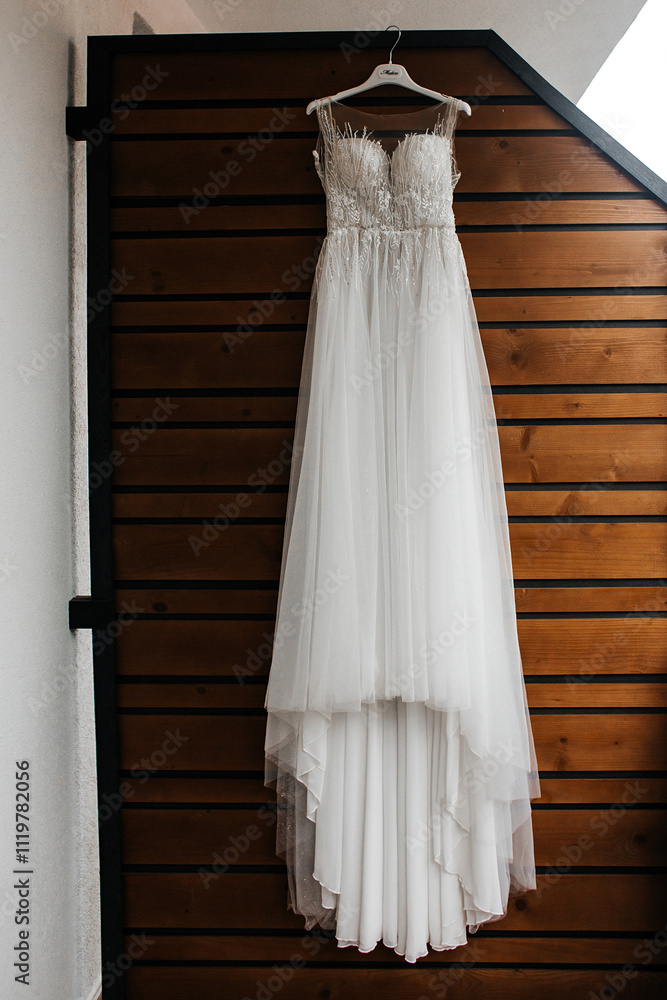 The dress is white with transparent elements on the shoulders and top. The top part of the dress is decorated with lace and has a sleeveless design. The dress is white with transparent elements on the shoulders and top. The top part of the dress is decorated with lace and has a sleeveless design.