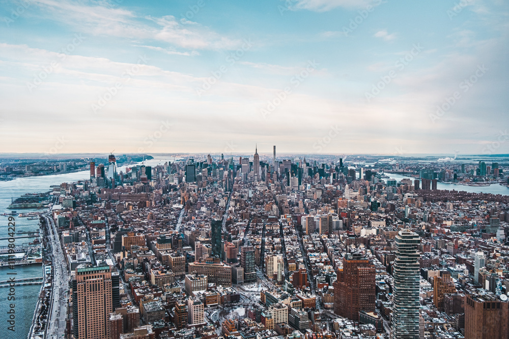 Obraz premium Stunning Aerial View of New York City Skyline Captured on a Crisp Winter Day Highlighting Skyscrapers and Urban Landscape With Snow-Covered Buildings Near the East River and Hudson River