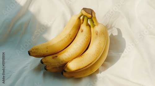 Fresh ripe bananas arranged artfully on a soft white surface showcasing vibrant colors and textures for food and wellness themes photo