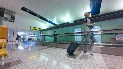 Modern airport interior with passenger walking along moving walkway in the airport