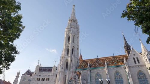 Stunning Matthias Church Gothic Architecture with Colorful Zsolnay Roof Tiles in Budapest - Historic Roman Catholic Church Showcasing Medieval Spires and Ornate Details Against Vibrant Blue Sky