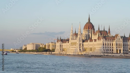 Stunning view of the Hungarian Parliament at sunset, with beautiful yellow tones enhancing the charm of Budapest, capturing the city's essence as day transitions into evening