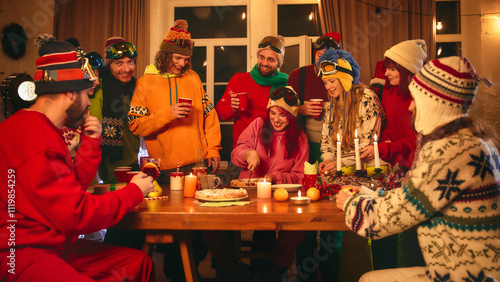 Valokuva Holiday cheer abounds as friends in vibrant ski gear toast with red cups around candlelit table, sharing pastries, oranges, and laughter in warm setting
