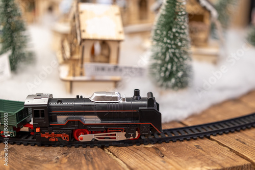 toy train traveling on railroad trac with winter landcape background and Christmas tree