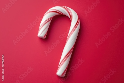 A Single Peppermint Candy Cane on a Vibrant Red Background Festive Holiday Treat Sweet Christmas Candy Cane photo