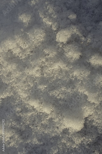 A high-resolution photograph of frozen snow with intricate crystal patterns and natural texture. Ideal for backgrounds, winter designs, and seasonal creative projects.