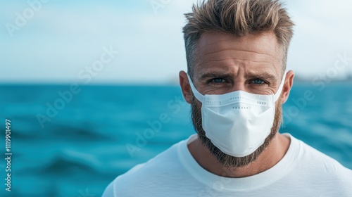 A contemplative man wearing a medical mask gazes thoughtfully toward the serene ocean horizon, conveying themes of contemplation, safety, and tranquility in nature. photo