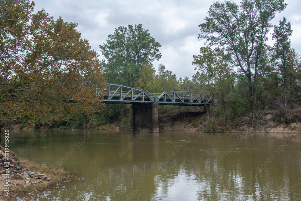 Obraz premium Autumn scenery and a bridge view over the Little Missouri River, or Little Mo running from the Ouachita Mountains of southwest Arkansas, USA