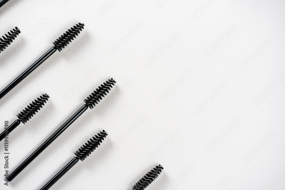 Black brushes for applying mascaras on eyelashes and eyebrows directed to the side on white background. Beauty and female makeup. Black brushes for applying mascaras on eyelashes and eyebrows directed to the side on white background. Beauty and female makeup.