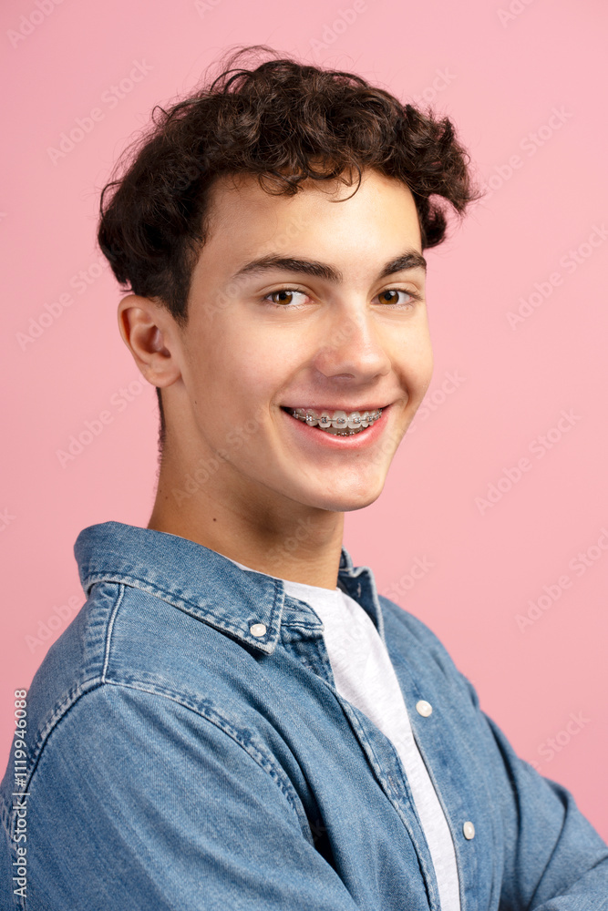 Closeup, happy, attractive teenager, boy with braces wearing casual clothes on pink background Closeup, happy, attractive teenager, boy with braces wearing casual clothes on pink background