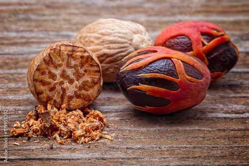 Nutmeg (Myristica fragrans), Myristicaceae. Spice, fresh nut with mace. On wooden table.