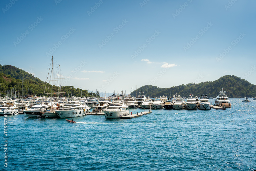 Obraz premium Port marina of Gocek in Turkey with many docked superyachts, sailing and motor boats on a sunny day with blue sky