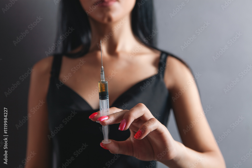 Fototapeta premium woman holding syringe in her hand, close up