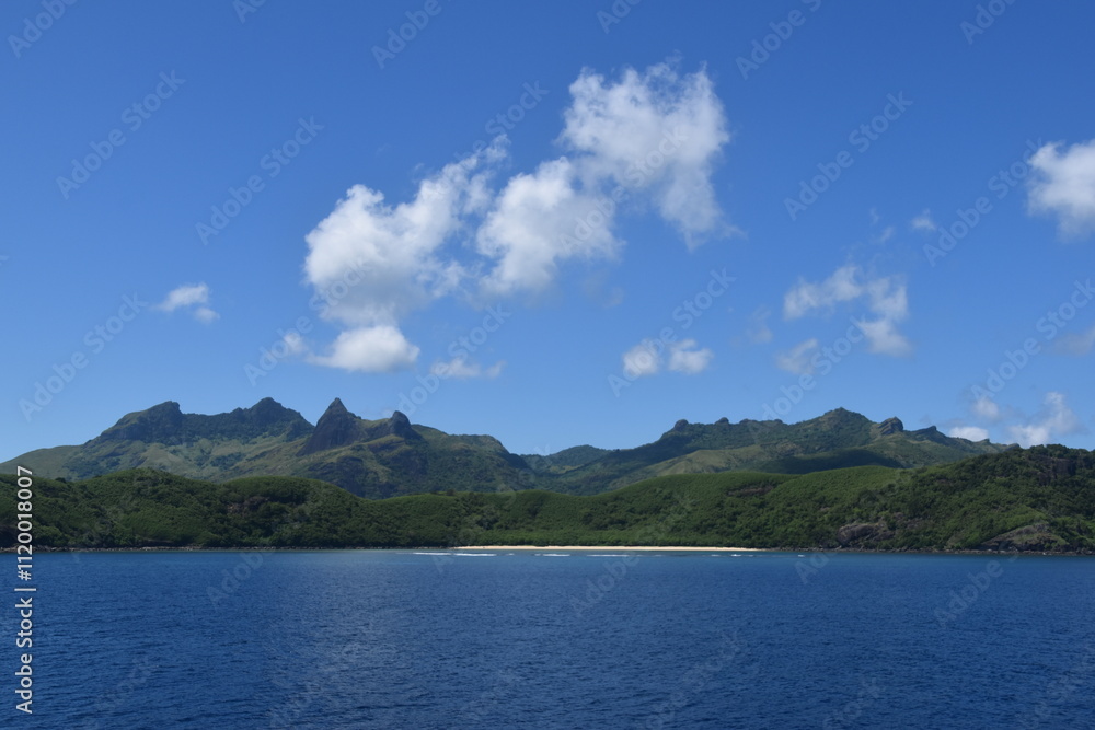 A lush green tropical paradise island with palm trees and white sandy beaches on Fiji in the Pacific Ocean A lush green tropical paradise island with palm trees and white sandy beaches on Fiji in the Pacific Ocean