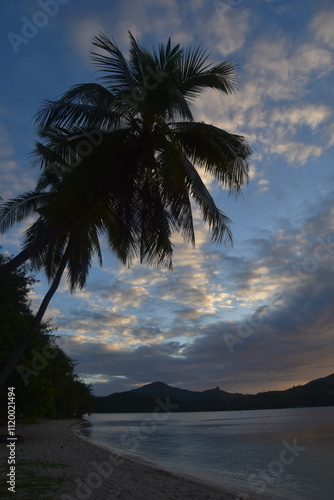 Stunning Pacific Ocean sunset with beams of colourful light shining up from the sea and islands in Fiji photo