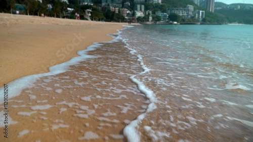 Beautiful sandy Hong Kong beach at the sea with clear blue water during tide in sunshine