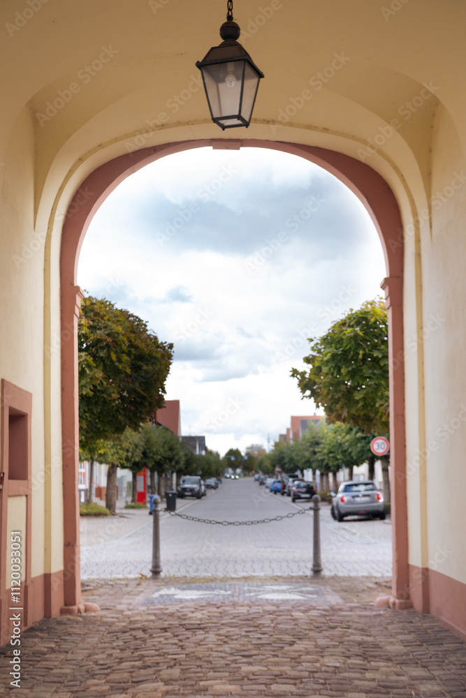 Fototapeta premium arch under town hall at Amalienstrasse 35 in historic city center of Karlsdorf-Neuthard, Now this building local museum, city landmark Germany