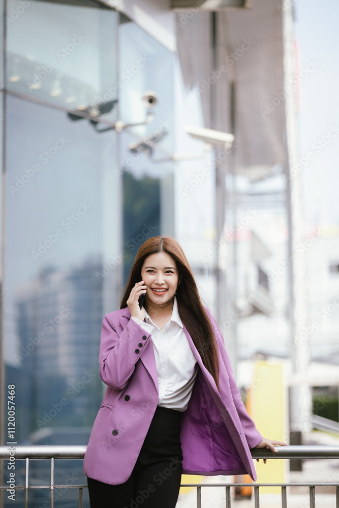 A businesswoman stands outdoors amidst a vibrant city, smiling while using her smartphone. A businesswoman stands outdoors amidst a vibrant city, smiling while using her smartphone.