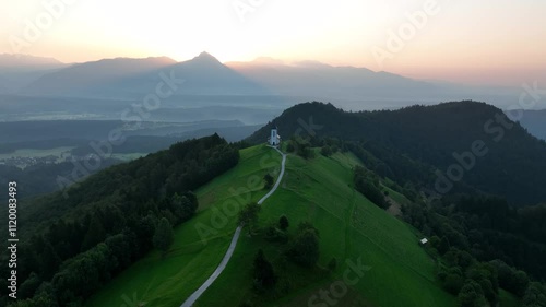 Drone shot of the Catholic church of Saint Primus and Felician with a green landscape of hills photo