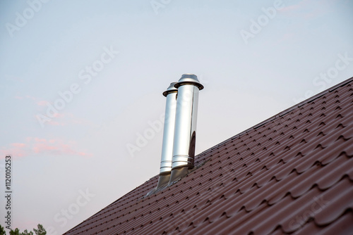 Foto Stainless steel chimney smokestack pipe on the roof