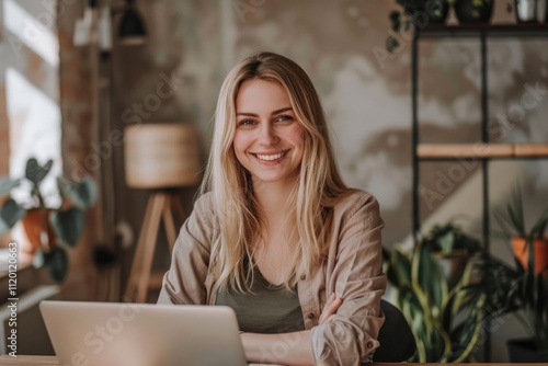 Portrait of happy female programmer in office with laptop.