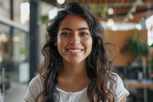 Latin college student or teacher smiling in campus. Happy professional woman in modern office.