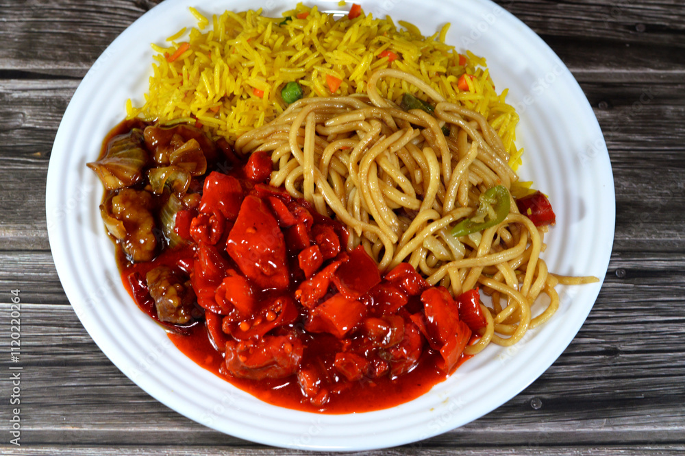Plate of Traditional Chinese food cuisine of grilled chicken breast pieces, chili chicken with vegetables, long grain yellow Basmati rice with vegetables and Chinese noodles with onions and soy sauce Plate of Traditional Chinese food cuisine of grilled chicken breast pieces, chili chicken with vegetables, long grain yellow Basmati rice with vegetables and Chinese noodles with onions and soy sauce