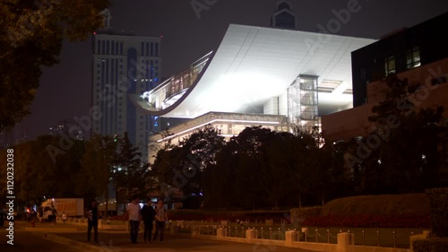 People Walk by Brightly Lit Shanghai Opera Theater Building at Night 4k
