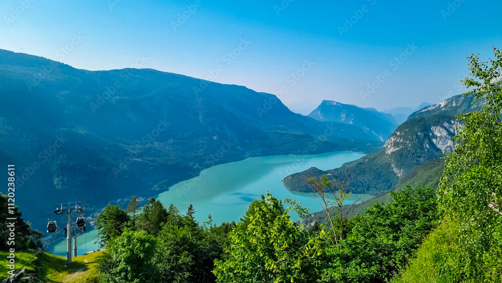 Cable car Funivie Molveno Pradel overlooking alpine lake Lago di Molveno in mountain retreat town Molveno, Trentino, Italy. Surrounded by forest and mountains of Brenta Dolomites. Tourism in Alps