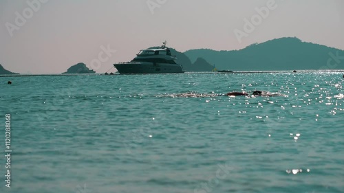 Man swims in the sea at the Hong Kong beach in sunshine, China