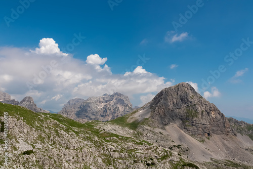 Scenic view of cloud covered rocky rugged mountain peak of Cima Dei Lasteri in majestic Brenta Dolomites, Trentino, Italy. Wanderlust in alpine wilderness. Hiking in pristine Italian Alps in summer photo