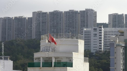 Hong Kong flag waving in the wind and tall blocks of houses in the background in China