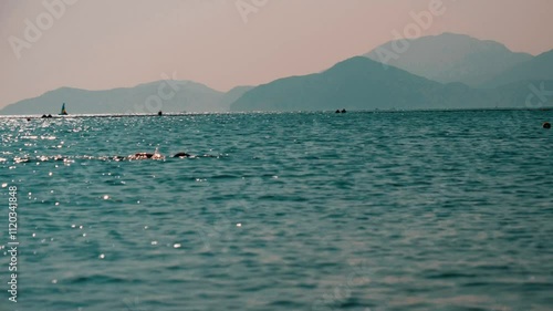 Sporty man in a swimming cap swims in the sea at the Hong Kong beach in sunshine, China