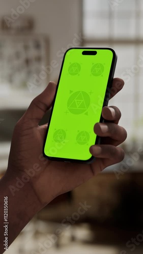 Wallpaper Mural GREEN SCREEN CHROMA KEY A hand holding a smartphone with a green screen in a cozy home environment with natural daylight and a modern interior Torontodigital.ca