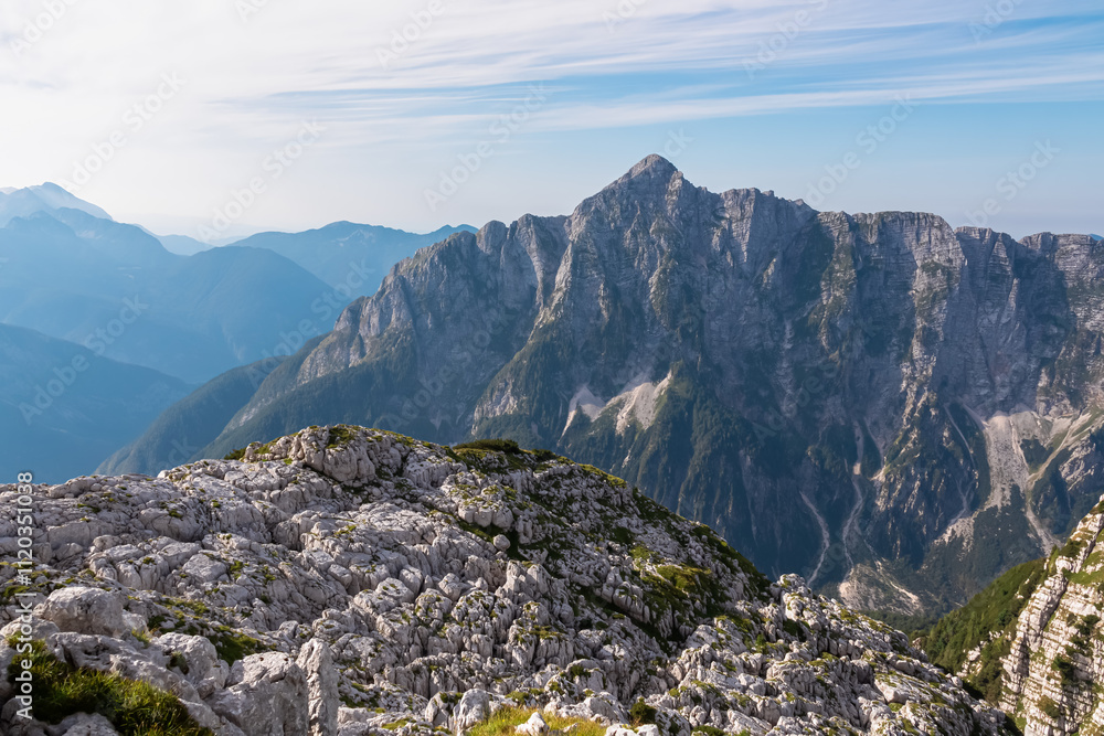 Obraz premium Scenic view of pristine rugged mountain peaks of Kanin massif, Julian Alps, Italy, Europe. Wild hiking trail along majestic ridges in Triglav National Park. Wanderlust alpine wilderness in summer. Awe
