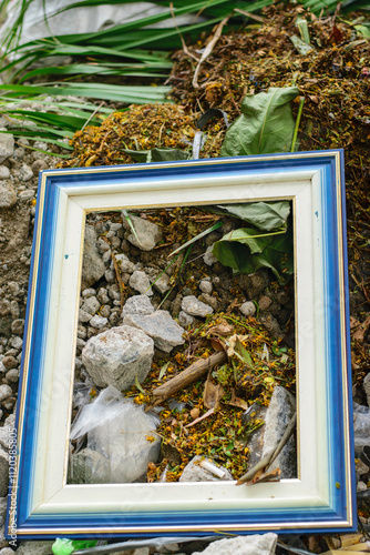 Discarded Picture Frame Amidst Natural Decay and Rocks