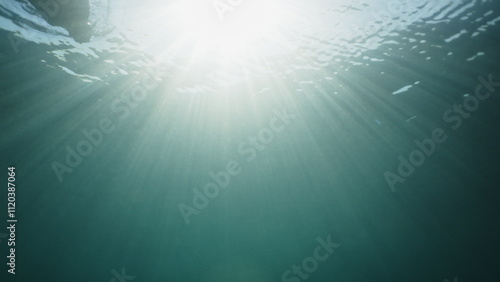 Amazing bright underwater light with sun rays in transparent blue ocean. Sun underwater beams rays sun shine underwater relaxing ocean scenery backgrounds. Copy space background. Beautiful reflection