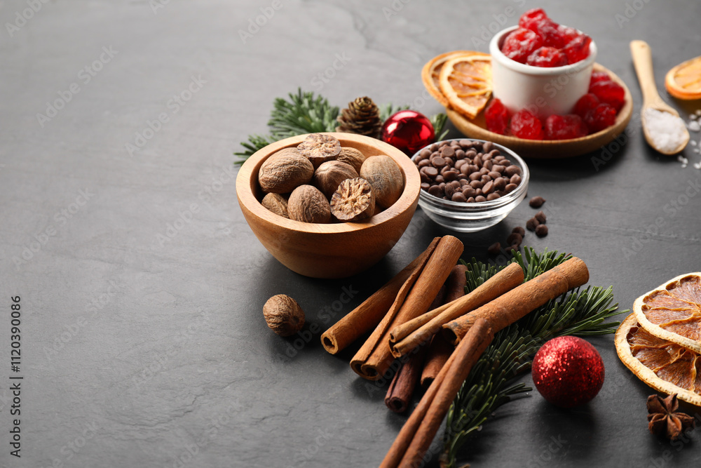 Different aromatic spices and fir tree branches on black table. Christmas season Different aromatic spices and fir tree branches on black table. Christmas season