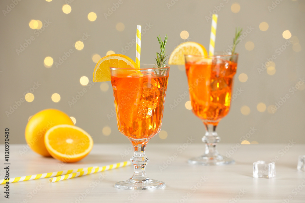 Tasty Christmas cocktail in glasses on white wooden table against blurred lights Tasty Christmas cocktail in glasses on white wooden table against blurred lights