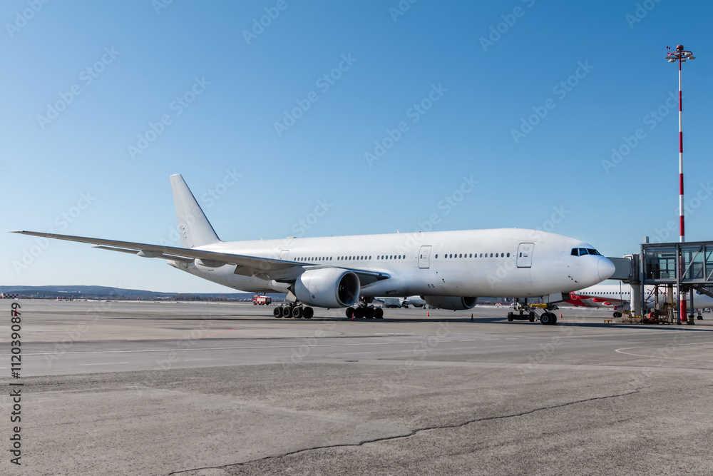 White wide body passenger jet plane at the gateway on the airport White wide body passenger jet plane at the gateway on the airport