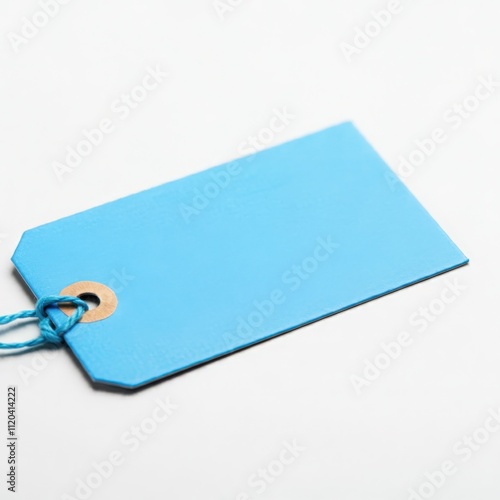 Minimalistic blue blank price tag with string on white surface for branding, sales, advertising, merchandise, and creative design concepts. photo