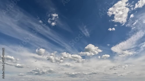 Fantastic endless clouds in the blue skies. 4K video (Ultra High Definition) of cloudscape and bright sun. Sky and clouds Timelapse. Sun shines through the clouds on the blue sky background.