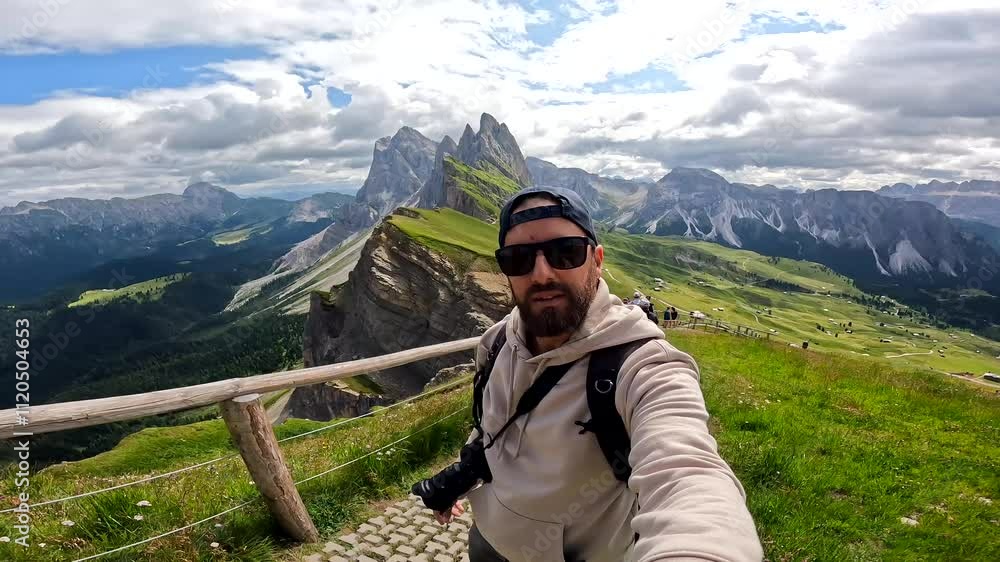 Photographer taking selfie in the dolomites enjoying seceda peaks in summer Photographer taking selfie in the dolomites enjoying seceda peaks in summer