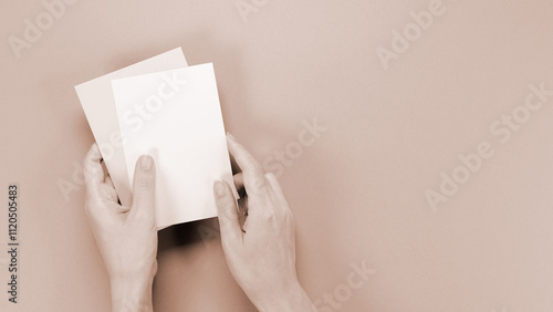 mockup envelop with empty space for text and design in hand of woman on brown background. Colour of the year Mocha Mousse, greeting card, layout for a slogan. photo